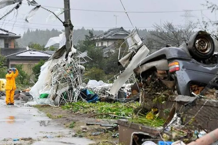 Seorang petugas berdiri di tengah puing-puing menyusul topan kuat di Ichihara, Chiba dekat Tokyo/AP
