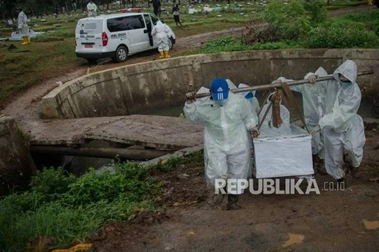 Petugas mengusung peti jenazah yang meninggal dunia karena Covid-19 untuk dimakamkan di TPU Srengseng Sawah, Jakarta. (dok Republika)