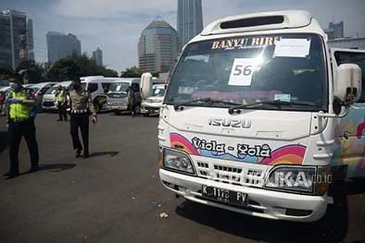[Ilustrasi] Seorang polisi melintas di depan mobil travel gelap yang terjaring dalam operasi khusus di titik penyekatan di Polda Metro Jaya, Jakarta, Senin (11/5/2020) (Foto: Republika/Prayogi)