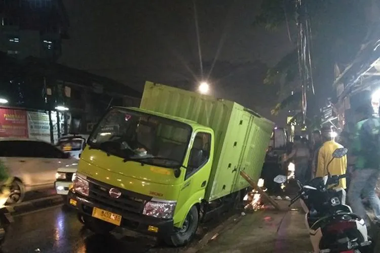 Truk bernomor polisi T 9452 AB terjebak di Jalan Palmerah Barat III, Palmerah Jakarta Barat akibat jalan ambles bekas galian kabel listrik saat hujan di Jakarta, Selasa (8/10/2019)/Antaranews