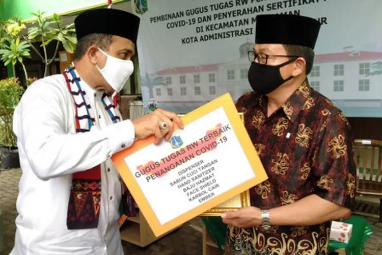 Wali Kota Jakarta Timur, Muhammad Anwar, memberikan apresiasi kepada salah satu perwakilan gugus tugas RW. (sumber: timur.jakarta.go.id)