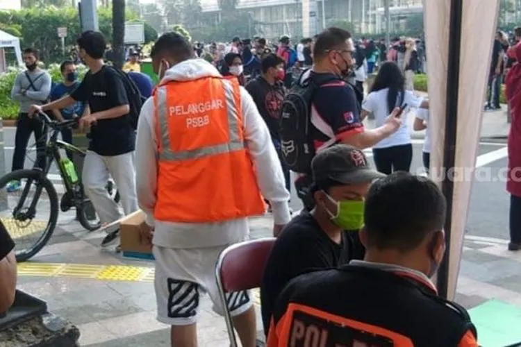 Warga tak pakai masker di CFD Jakarta diminta sapu jalan. (Suara.com/Fakhri Fuadi)