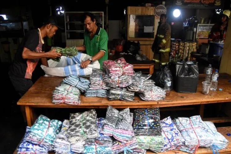 Pedagang mengevakuasi barang dagangan usai terjadinya kebakaran di Gudang baju blok C Pasar Tanah Abang, Jakarta, Senin (22/4/2019). Sebanyak 20 unit mobil pemadam kebakaran dikerahkan untuk memadamkan api pada kebakaran yang terjadi di lantai 3 pasar tersebut. ANTARA FOTO/M Risyal Hidayat/aww.