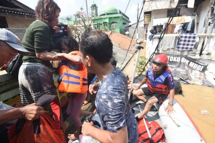 Petugas Damkar mengevakuasi warga terdampak banjir di kawasan Rawajati, Jakarta Selatan, Jum'at (26/4/2019). Banjir akibat curah hujan yang tinggi di kawasan Bogor itu mengakibatkan ratusan rumah di enam RT Kelurahan Rawajati terendam hingga mencapai ketinggian empat meter dan sejumlah warga diungsikan. ANTARA FOTO/Indrianto Eko Suwarso/aww.