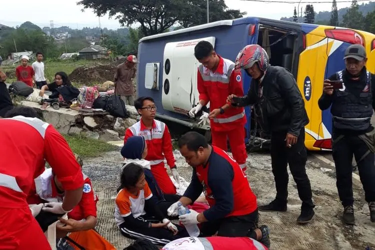 Petugas memberikan penanganan sementara usai terjadi kecelakaan bus terguling (Dok. Istimewa)