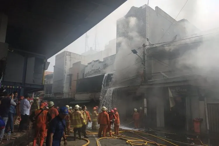 Petugas Pemadam Kebakaran berusaha memadamkan api yang membakar gudang kembang api di kawasan Pasar Pagi, Tambora, Jakarta Barat, Jumat (21/6/2019).  ANTARA FOTO/Muhammad Adimaja. (Muhammad Adimaja)