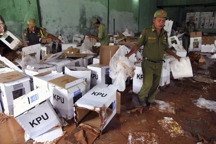 Petugas Hansip membawa kotak surat suara Pemilu 2019 yang rusak akibat terkena banjir di Gedung GOR Serbaguna, Ciseeng, Kabupaten Bogor, Jawa Barat, Senin (15/4/2019). Sedikitnya 800 kotak surat suara Pemilu 2019 rusak akibat banjir yang menjebol tembok Gedung GOR Serbaguna tersebut pada Senin (14/4/2019) malam. ANTARA FOTO/Arif Firmansyah/ama.
