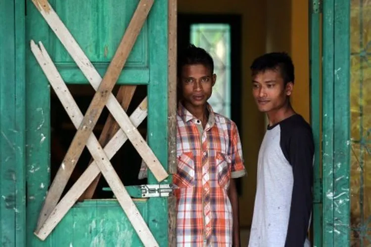 Dua orang imigran Rohingya asal Myanmar berdiri di pintu barak tempat penampungan sementara area SKB Cot Gapu, Kabupaten Bireuen, Aceh, Sabtu (30/3/2019). Dari 79 imigran etnis muslim Rohingya yang ditampung di SKB Cot Gapu pascaterdampar di perairan Bireuen Aceh pada 20 April 2018 itu kini hanya tersisa dua orang atas nama Mohamed Islam dan Mohamed Yusuf, sementara 77 orang lainnya dilaporkan telah melarikan diri dari tempat penampungan. ANTARA FOTO/Rahmad/wsj.