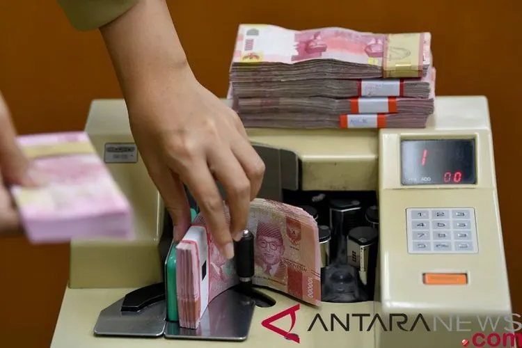 Karyawan menghitung mata uang rupiah di gerai penukaran mata uang asing di Jakarta. (ANTARA FOTO/Sigid Kurniawan)