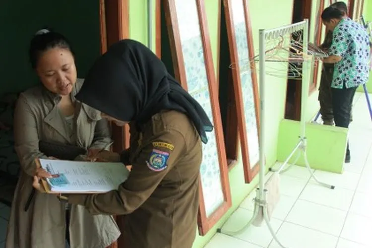 Petugas Satpol PP Kota Tangerang Selatan memeriksa Kartu Tanda Penduduk (KTP) seorang warga saat Pendataan Bina Kependudukan pascalebaran di sejumlah rumah kontrakan di Ciputat, Tangerang Selatan, Banten, Kamis (20/6/2019). Kegiatan itu guna mendata para pendatang baru dan mengantisipasi masuknya pendatang gelap sebagai antisipasi terjadinya tindak kejahatan. ANTARA FOTO/Muhammad Iqbal/aww.