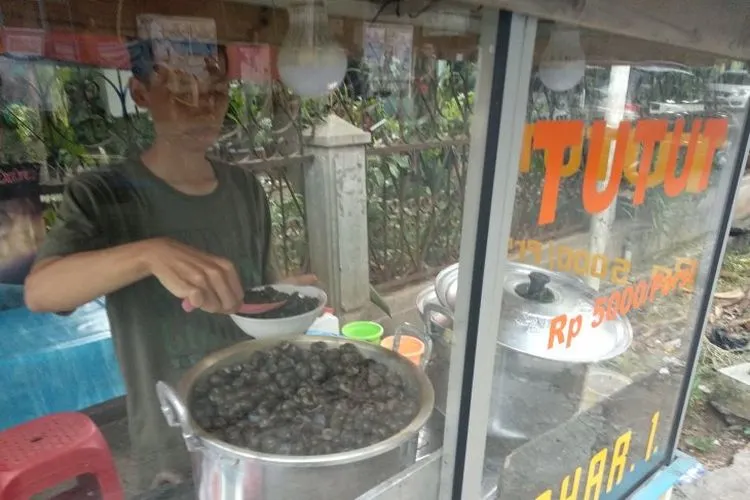 Pedagang kuliner tutut menyiapkan sajian untuk pelanggannya di Tanah Sareal, Bogor, Jawa Barat, beberapa waktu lalu. (ANTARA News/Aditya Pradana Putra)