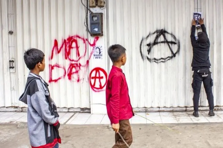 Seorang buruh dari Aliansi Buruh Karawang melakukan aksi vandalisme saat mengikuti aksi Hari Buruh Internasional (May Day) di klawasan By Pass, Karawang, Jawa Barat, Rabu (1/5/2019). Aksi tersebut untuk menyalurkan aspirasi dan kekecewaan buruh terhadap pemerintah. ANTARA FOTO/M Ibnu Chazar/ama.