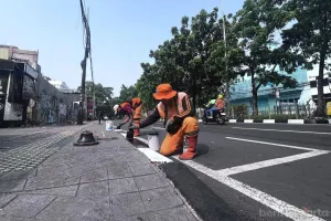 Petugas Penanganan Prasarana dan Sarana Umum (PPSU) Kelurahan Rawamangun, Kecamatan Pulo Gadung, Jakarta Timur, melakukan pengecatan kanstin di 18 ruas jalan. (Sumber: beritajakarta.id | Foto: beritajakarta.id)