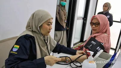 Pemeriksan kesehatan kepada warga dalam program Pemeriksaan Kesehatan Gratis (PKG) di Puskesmas Pembantu (Pustu) Sukahaji. 