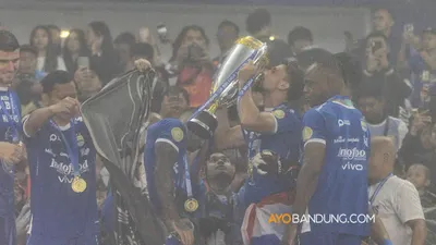 Pemain dan ofisial tim Persib Bandung mengangkat piala usai pertandingan melawan Persis Solo dalam Liga 1 2024/2025 