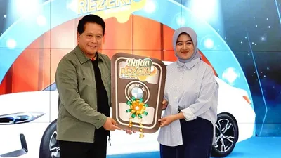 Direktur Utama BSI Hery Gunardi (kanan) menyerahkan hadiah utama  1 (satu) unit mobil BMW 321i kepada nasabah BSI KCP Cianjur Cipanas 2 Siti Rahmawati (kanan) pada acara Seremoni Penyerahan Hadiah Hujan Rezeki BSI Mobile di The Tower Jakarta, Jumat (19/7).