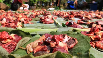 Warga membungkus daging kurban dengan daun tisuk dan daun pisang di Kampung Berseri Astra (KBA) Cidadap Ecovillage, Desa Padalarang, Kecamatan Padalarang, Kabupaten Bandung Barat, Rabu 19 Juni 2024. 