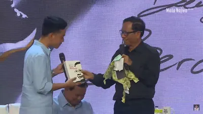 Cawapres dari pasangan nomor urut tiga Mahfud MD, memberikan sebuah buku biografi kepada&nbsp;cawapres dari kandidat lain,&nbsp;Gibran&nbsp;Rakabuming.