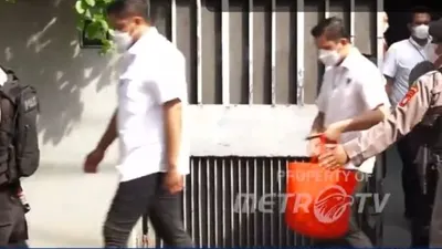 Tim penyidik keluar dari kediaman Firli dengan membawa sebuah koper berwarna abu-abu dan juga sebuah tote bag berwarna orang yang diduga berisi barang bukti.