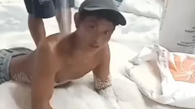 Viral! Seorang Pria Tanpa Busana &lsquo;Mandi&rsquo; Beras Bulog di Gudang, Warganet: Ya Ampun Jahatnya