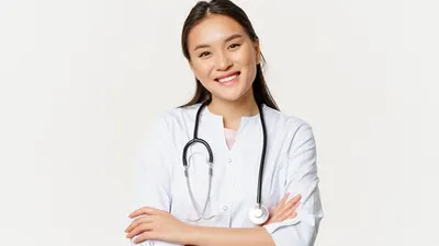 Asian female doctor, physician in medical uniform with stethoscope, cross arms on chest, smiling and looking like professional, white background.