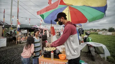Warga ngabuburit di Kampung Ramadan Bunut, Margahurip, Kabupaten Bandung, Jumat 31 Maret 2023. Kampung Ramadan Bunut diinisiasi oleh Yayasan Cerebrum bersama Karang Taruna Bunut 09 dan menghadirkan bazzar makanan dari 103 UMKM makanan, minuman, hingga fesyen. 