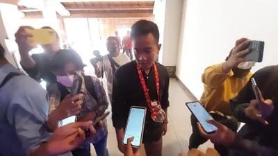 Wali Kota Solo Gibran Rakabuming Raka mengalungkan botol minum Mixue  saat ngantor di Balai Kota Solo, Rabu, 4 Januari 2022. 