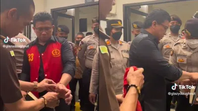 Viral video Ferdy Sambo yang menggunakan rompi berwarna merah bertuliskan angka 33 mengadahkan tangan kirinya untuk dibukakan borgolnya.