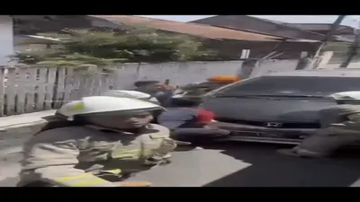 Petugas Damkar mencoba memindahkan mobil warga yang terpakir di jalan sehingga menghalangi evakuasi