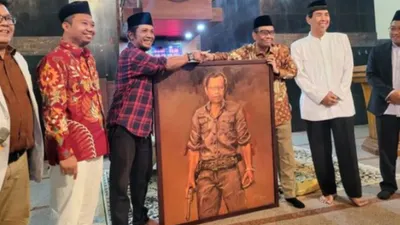 Profesor Mahfud MD saat menerima lukisan karya Perupa Wuri Hantoro berpakaian flanel merah di Kampus UIN Sunan Kalijaga .
