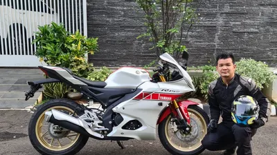 Kehadiran All New R15 Connected mendapatkan respon positif dari konsumen Indonesia yang tertarik dengan beragam keunggulan motor generasi terbaru R Series ini. Penampilan All New R15 Connected menjadi salah satu alasan konsumen ingin merasakan keseruan pengalaman berkendara bersama motor ini.  Apalagi untuk penggemar motor sport yang menyambut antusias dan menaruh minat untuk memiliki All New R15 Connected karena menyukai desain R-DNA yang merupakan nilai istimewanya. Willysim Salim misalnya sebagai pecinta motor sport, mengakui All New R15 Connected unggul dari segi desain sehingga membuat dirinya melakukan pembelian.  &rdquo;Saya suka dengan desain All New R15 Connected yang menyerupai R1 dan R7, selain itu juga mengambil desain M1 buat saluran udaranya. Salah satu faktor ini yang membuat saya membeli motor ini dan memilih edisi terbatas livery 60 tahun Yamaha tampil di balapan dunia. Untuk motor berkapasitas 155cc dengan tampilan mirip moge ini keren banget, nuansa racing look juga sangat kuat. Fitur-fiturnya juga berkelas, dengan adanya Quick Shifter* mendukung akselerasi karena proses perpindahan gigi lebih cepat, lalu suspensi Upside Down meningkatkan handling dan Traction Control System* menjaga ban belakang agar tidak kehilangan traksi saat motor sedang berakselerasi,&rdquo; papar Willysim Salim yang berprofesi sebagai pengusaha.  Dia menyebutkan puas dan bangga memiliki All New R15M Connected-ABS Yamaha World Grand Prix 60th Anniversary livery ini. Motor barunya itu akan dijadikannya sebagai koleksi dan dipajang di rumah. Selain itu, juga untuk riding buat sunmori dan hang out bersama teman-temannya. Posisi berkendaranya yang enak membuat dia semakin menyukai motor ini.  R-DNA Design merupakan salah satu keunggulan All New R15 Connected yang ditawarkan kepada konsumen. All New R15 Connected memiliki desain generasi terbaru R-Series dengan R-DNA dan memadukan karakter line up motor Yamaha berkapasitas besar. Tampilan barunya terlihat dari M-Shaped Intake Duct yang merupakan saluran udara berbentuk M diadopsi dari gaya YZR-M1. Pada bagian itu terdapat satu lampu utama dengan projector LED dan ditambah lagi dengan Twin Eyes LED Position Light terinspirasi dari YZF-R1 dan YZF-R7 yang makin menguatkan visualisasi gagah serta agresifnya wajah motor ini.  Sisi eksterior lainnya yang menghadirkan aura big bike look adalah full digital speedometer yang dirancang dengan konsep smart cockpit design terinspirasi dari YZF-R1*. Desain racing look lainnya terlihat dari kehadiran Triple Clamp* bergaya YZR-M1, fitur ini berfungsi memberikan keseimbangan kekuatan dan kekakuan sehingga meningkatkan handling pada motor. Selain itu, penggunaan jok dengan cover motif karbon* membuat pengendara kian merasa spesial. Kebanggaan pun didapatkan lewat keberadaan simbol 3D emblem logo R15M yang terletak di tangki dan fork caps biru berlogo R15M*. Body motor pun dirancang memiliki fairing aerodinamis untuk menunjang posisi berkendara yang sporty racing.  All New R15M Connected-ABS terdiri dari pilihan warna Icon Performance dan Yamaha World Grand Prix 60th Anniversary livery. Sedangkan All New R15 Connected memiliki warna Icon Blue dan Tech Black. All New R15M Connected-ABS dipasarkan dengan harga Rp 43.500.000 OTR Jakarta dan All New R15 Connected seharga Rp 38.900.000 OTR Jakarta. Sedangkan All New R15M Connected-ABS edisi terbatas World Grand Prix 60th Anniversary livery dibanderol Rp 44.100.000 OTR Jakarta.  *hanya terdapat pada All New R15M Connected-ABS. (dok. Yamaha)