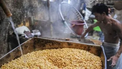Pekerja mengolah kedelai untuk membuat tempe dan tahu.