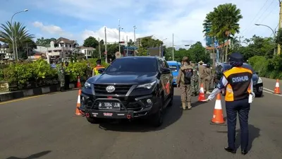 Petugas gabungan saat melakukan pemeriksaan surat keterangan sehat kepada wisatawan, di Simpang Gadog, Ciawi, Kabupaten Bogor.