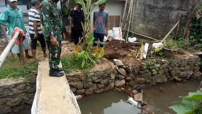 Petugas saat melakukan evakuasi jasad bayi, yang tersangkut di bebatuan Kali Cimahpar. (Dok. Polsek Cibinong)