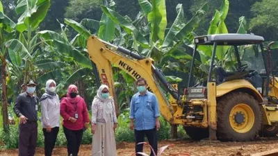 Petugas pemulasaraan jenazah, saat melakukan proses penggalian makam Covid-19 menggunakan alat berat. (Dok PUPR dan Disperumkim)