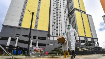 Petugas kesehatan Rumah Sakit Covid-19 Wisma Atlet Kemayoran Jakarta berjalan membawa kotak obat pasien.