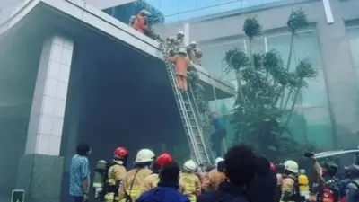 Petugas tengah berusaha memadamkan kebakaran Gedung Cyber 1 di Kuningan Barat, Jakarta Selatan, Kamis (2/12/2021) siang. 
