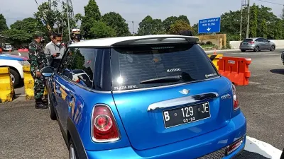 Ilustrasi - Petugas kepolisian saat memberikan sanksi tilang kepada pengendara Mini Cooper 