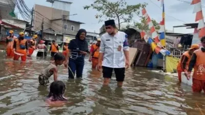 Lurah Pluit Helwin Ginting memonitor banjir rob di kawasan Pelabuhan Muara Angke, Penjaringan, jakarta Utara, Jumat (3/12/2021).