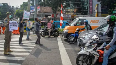 Satpol-PP Kota Bogor bersama musisi jalanan saat melakukan sosialisasi protokol kesehatan di simpang lampu merah Jambu Dua