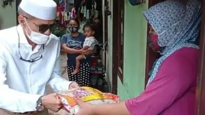 Habib Hasan Mulachela membagikan beras kepada warga warga di Kelurahan Semper Barat, Kecamatan Cilincing, Jakarta Utara, Kamis (4/2/2021).[Suara.com/ist]