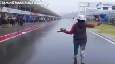 Aksi seorang pawang hujan di Sirkuit Mandalika saat gelaran MotoGP Indonesia, Minggu (20/3/2022).