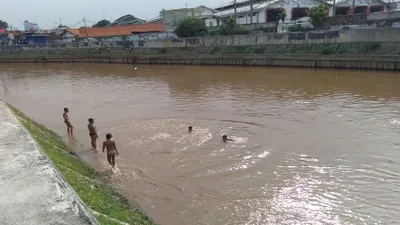 Anak-anak yang tinggal di wilayah bantaran Sungai Ciliwung, Jatinegara, Jakarta Timur, memanfaatkan sungai tersebut untuk bermain dan berenang.