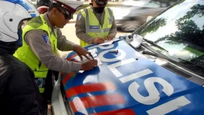 Ilustrasi polisi menilang kendaraan yang menyalahi aturan.