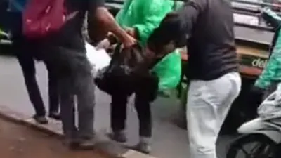 Seorang remaja yang terluka akibat bacokan usai tawuran dievakuasi warga lainnya.