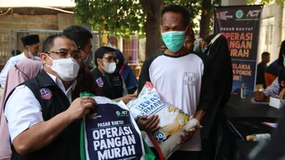 Presiden ACT Ibnu Khajar (kiri) saat memberikan paket sembako dalam Operasi Pangan Murah di Masjid Assuada, Kecamatan Koja, Jakarta Utara, Jumat 15 Oktober 2021. 
