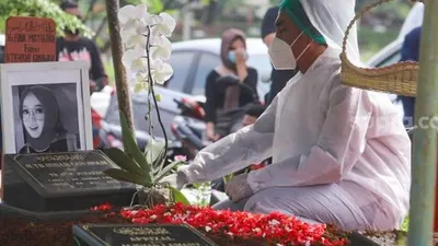 Suami mendiang Presenter Rina Gunawan, Teddy Syah berdoa di atas pusara sang istri saat prosesi pemakaman di TPU Tanah Kusir, Jakarta Selatan, Rabu (3/3/2021). [Suara.com/Alfian Winanto]