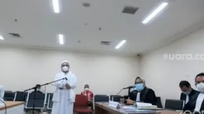 Habib Rizieq melakukan aksi berdiri dan bungkam selama persidangan, Jumat (19/3/2021). [Suara.com/ Bagaskara Isdiansyah]