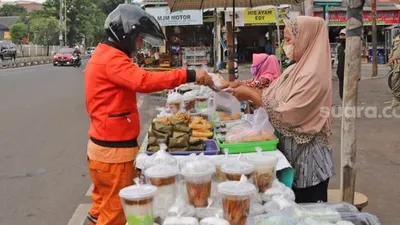 Pembeli memilih takjil untuk buka puasa di Jalan Panjang, Kebon Jeruk, Jakarta barat, Jumat (1/5). [Suara.com/Alfian Winanto]