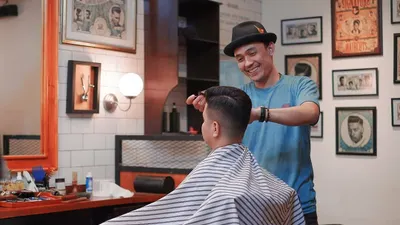 Leader Cut Palace Barbershop Saepul Arifin saat melakukan treatment kepada salah seorang pengunjung. 